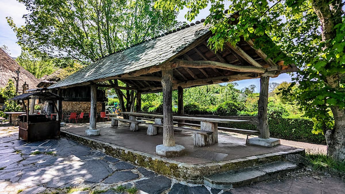 Merendero cubierto con estructura de madera y techo de pizarra en Balboa, León.