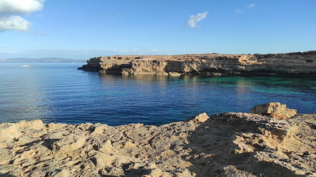 Cala de aguas tranquilas y cristalinas rodeada de acantilados en Mallorca.
