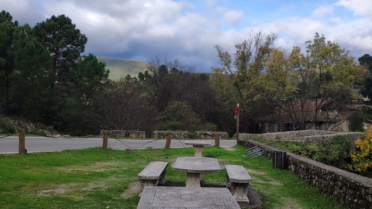 Área de picnic con mesas de piedra en la piscina natural de Acebo.