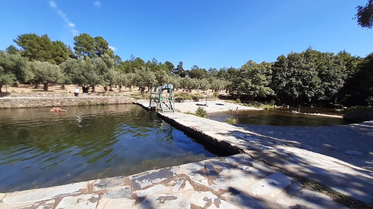 Piscina natural de Acebo con una pasarela de madera y aguas cristalinas.