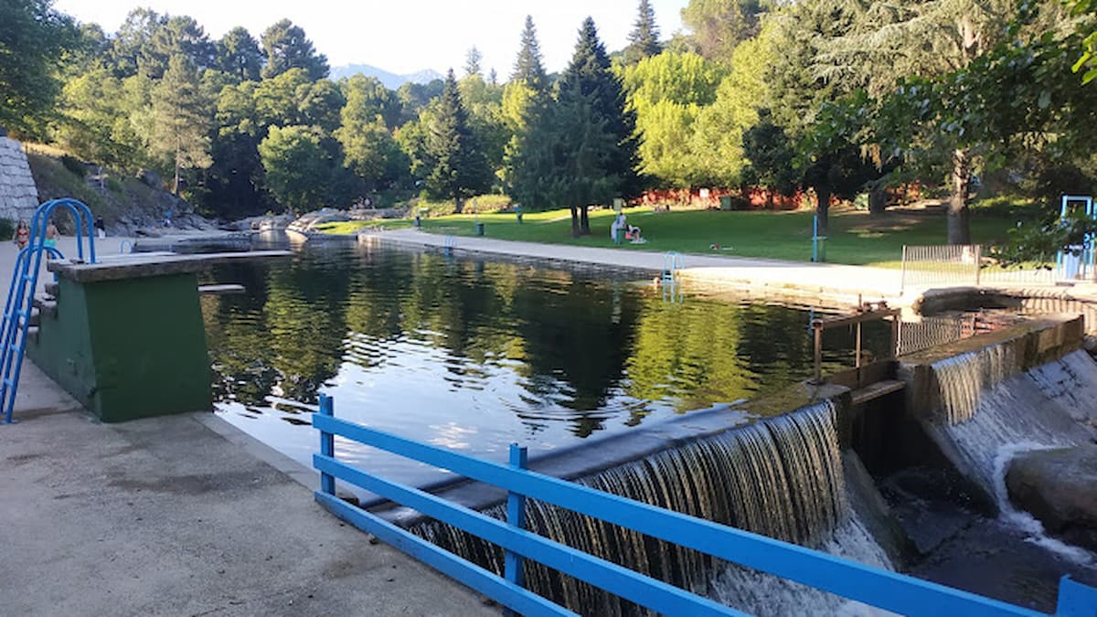 Cascada en las piscinas naturales de Arenas de San Pedro, con agua cayendo sobre una represa y escaleras para acceder al baño.