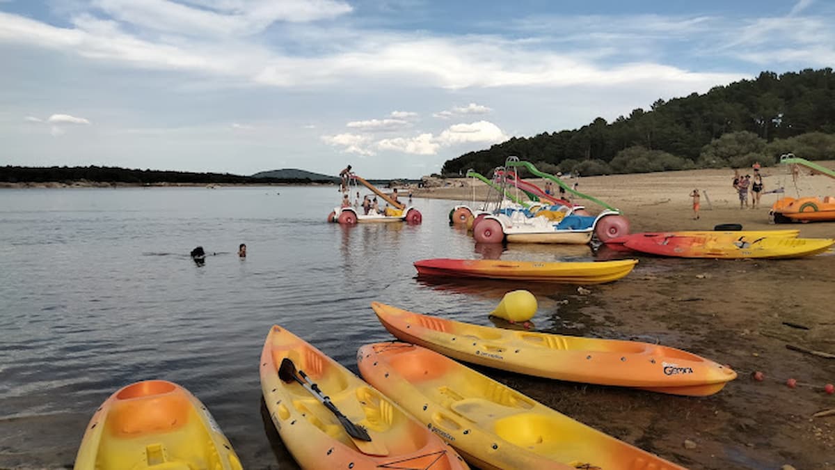 Kayaks y patines de agua en la orilla de Playa Pita, listos para ser utilizados en el pantano.